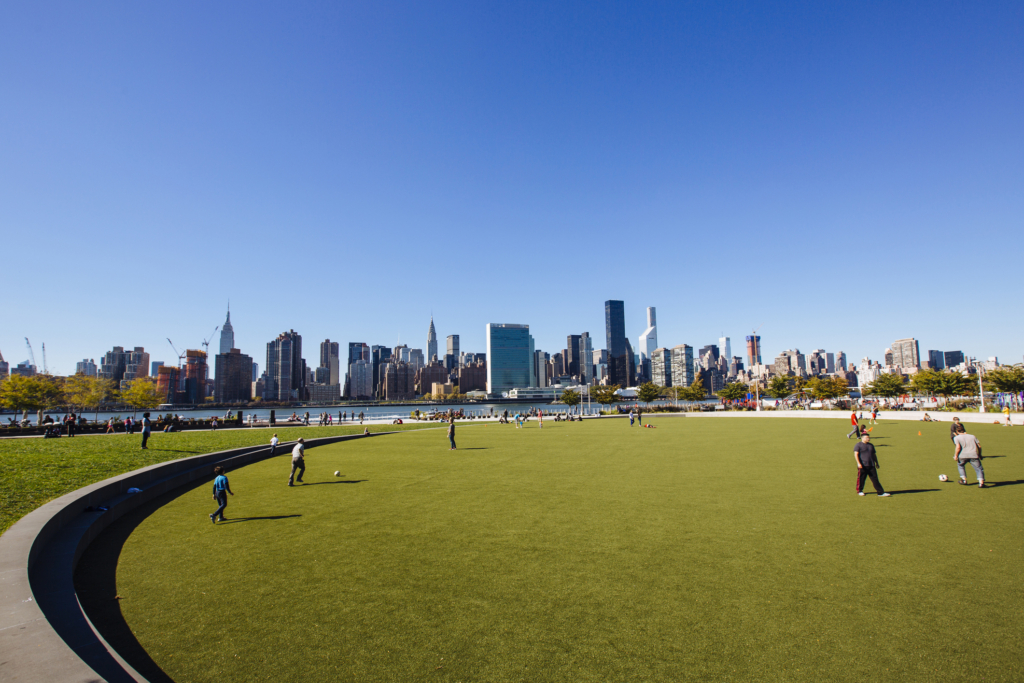 residents playing soccer on field in Hunters Point South Park in Long Island City