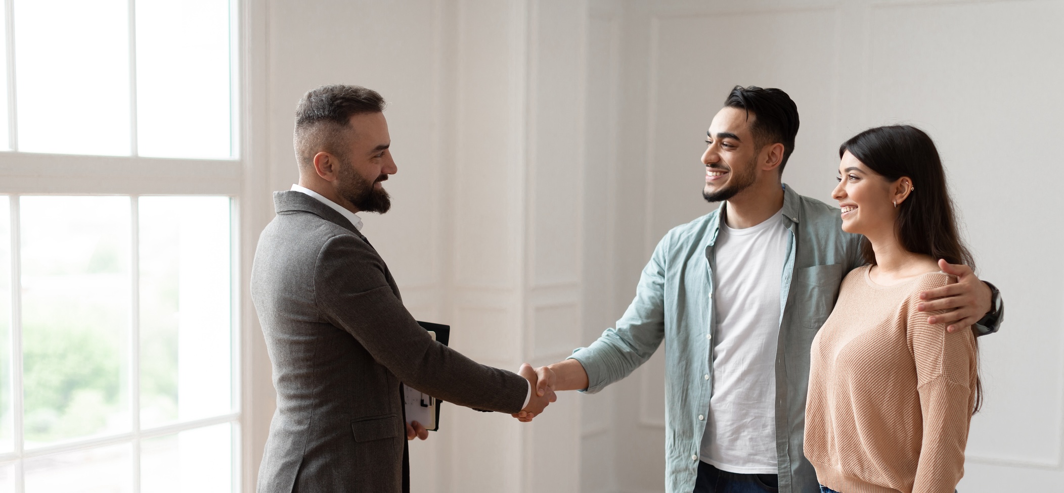 Young couple shaking hand with real estate agent - how to make a winning offer on an NYC home - header image