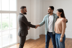 Young couple shaking hand with real estate agent - how to make a winning offer on an NYC home