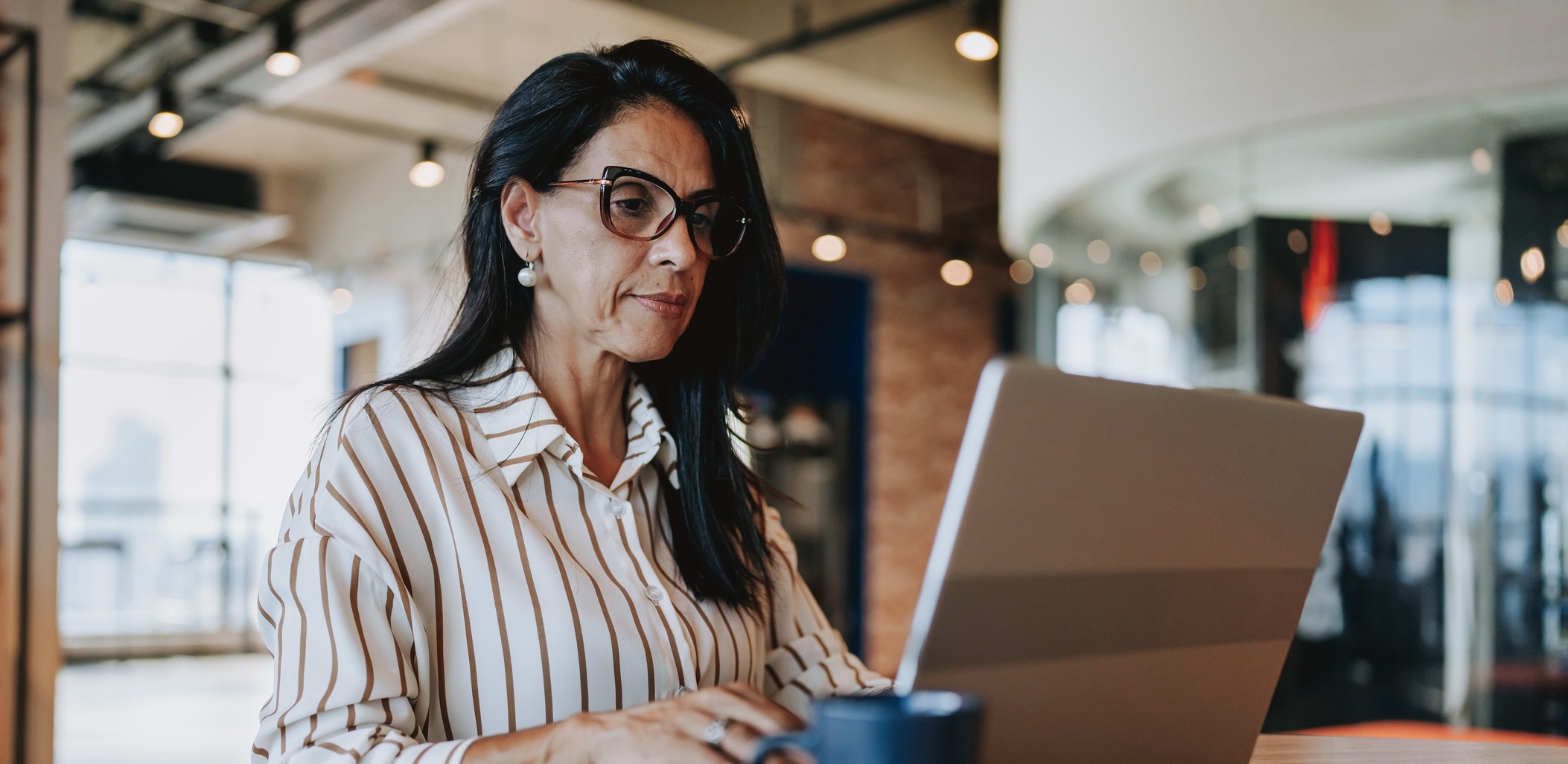 woman on laptop in an office - private listing networks hero image